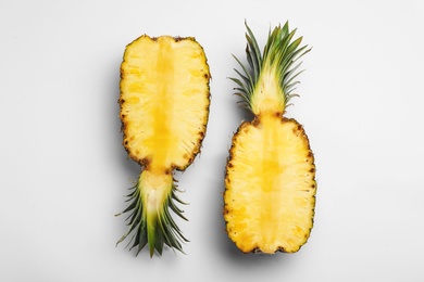 Photo of Halves of tasty raw pineapple on white background, top view