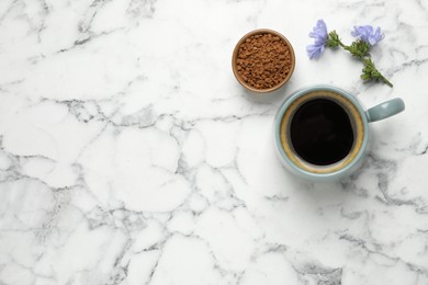 Photo of Cup of delicious chicory drink, granules and flowers on white marble table, flat lay. Space for text