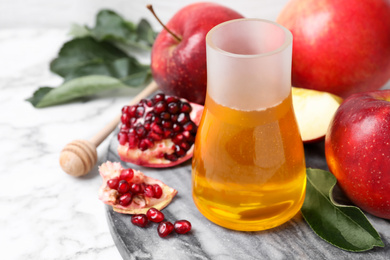 Photo of Honey, apples and pomegranate on white marble table. Rosh Hashanah holiday