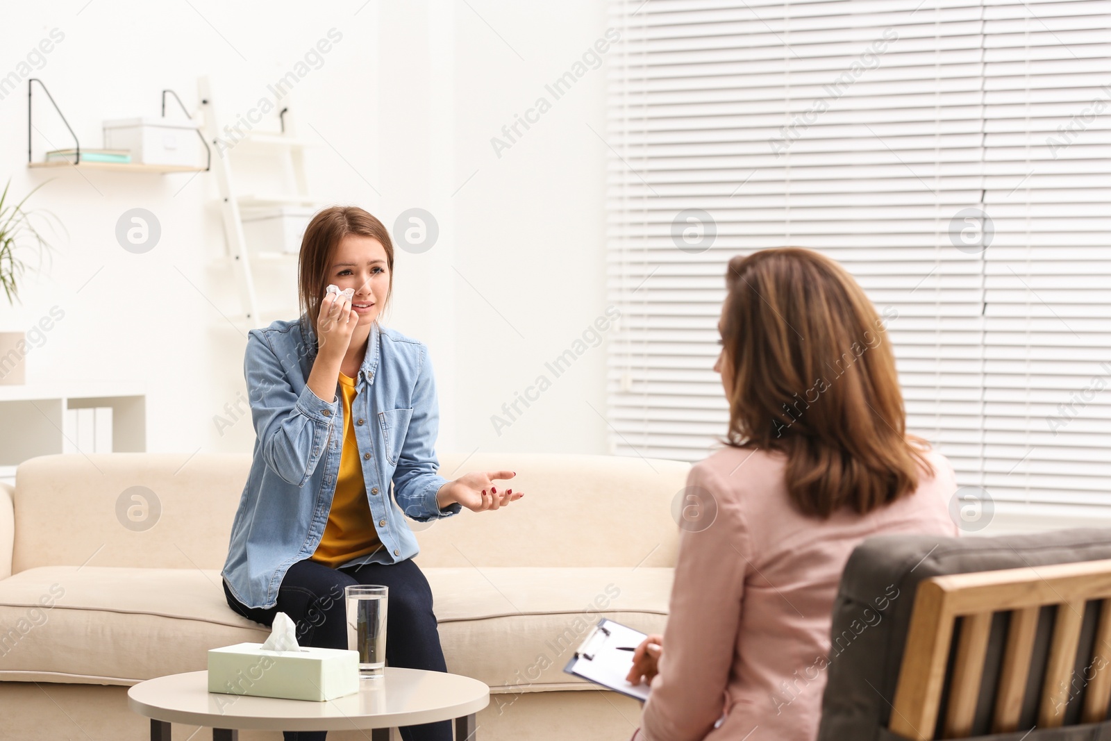 Photo of Psychotherapist working with teenage girl in office