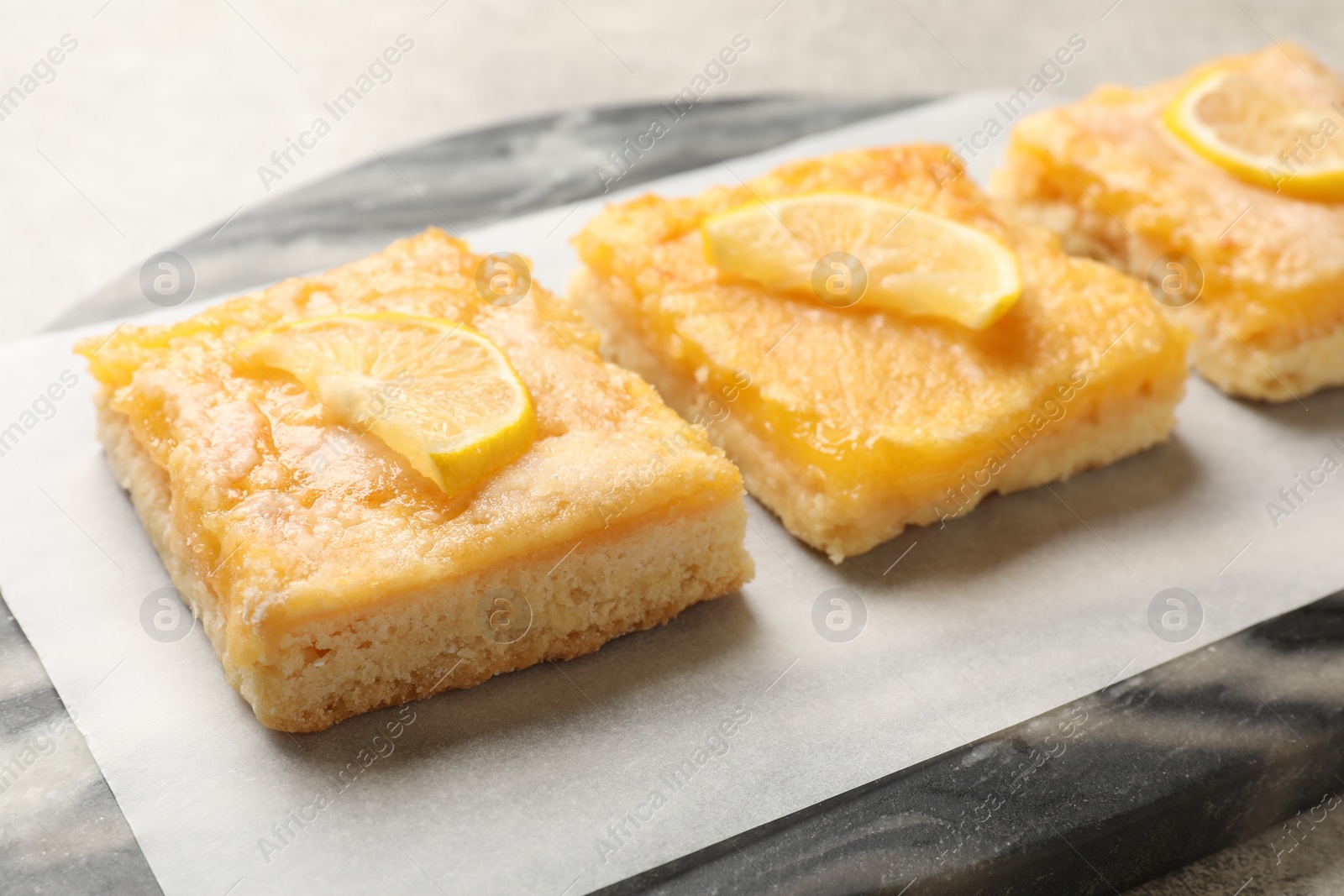 Photo of Tasty lemon bars on table, closeup view