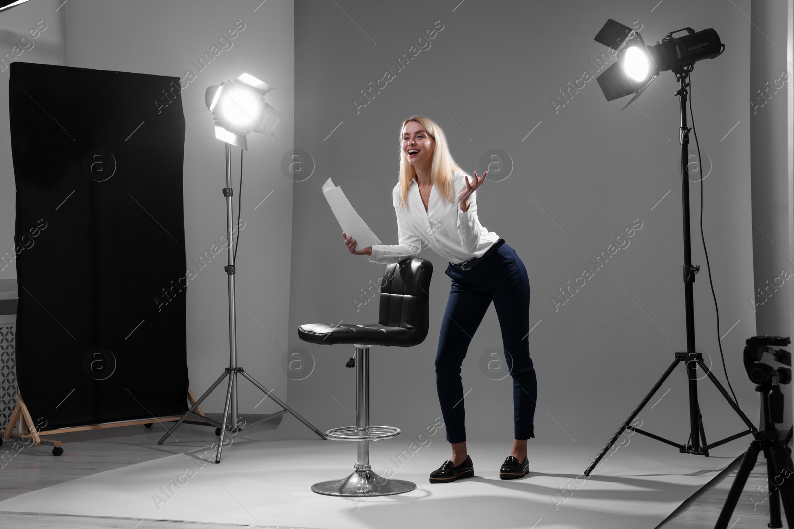 Photo of Casting call. Emotional woman performing against grey background in studio