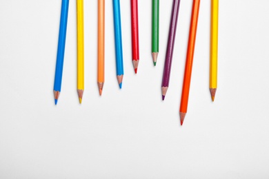 Photo of Color pencils on white background, top view. Space for text