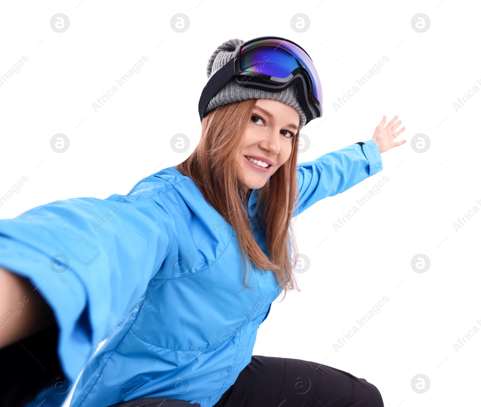 Photo of Beautiful woman in ski goggles taking selfie on white background