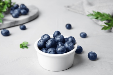 Bowl of tasty blueberries on grey stone table