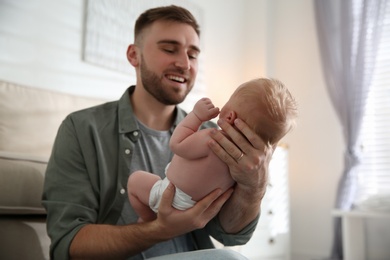 Photo of Father with his newborn son at home