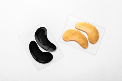 Photo of Packages with under eye patches on white background, top view. Cosmetic product