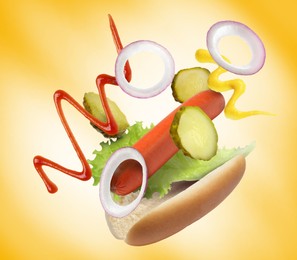 Hot dog ingredients in air on golden gradient background