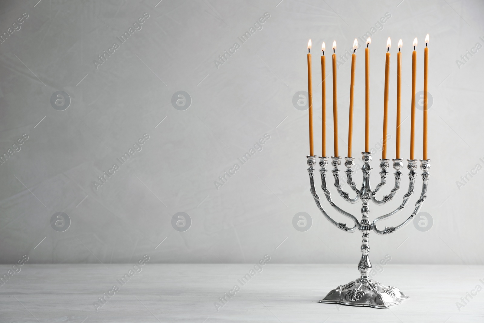 Photo of Hanukkah menorah on table against light background