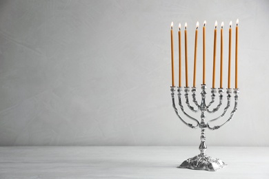 Photo of Hanukkah menorah on table against light background