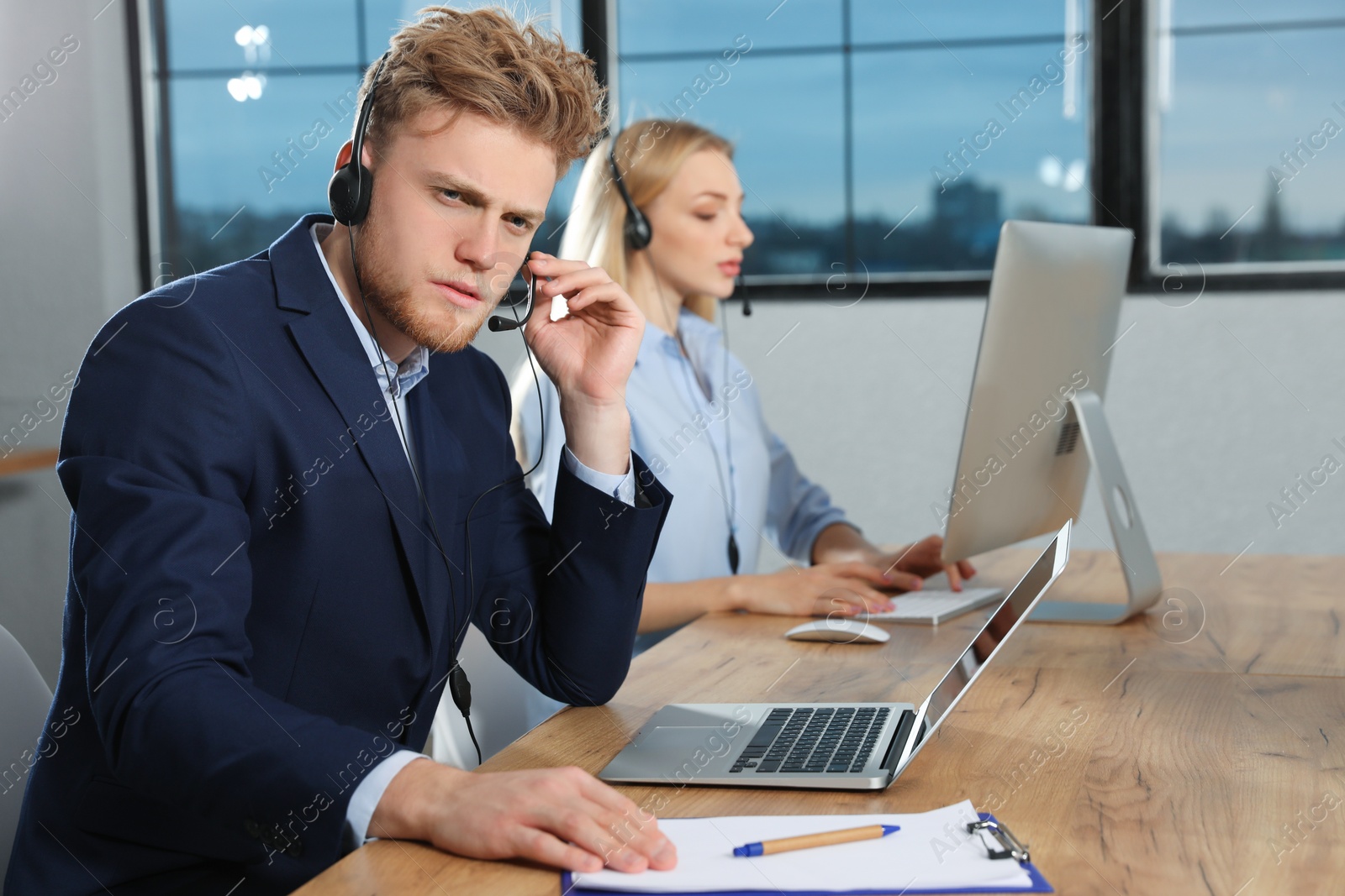 Photo of Technical support operator with colleague in modern office