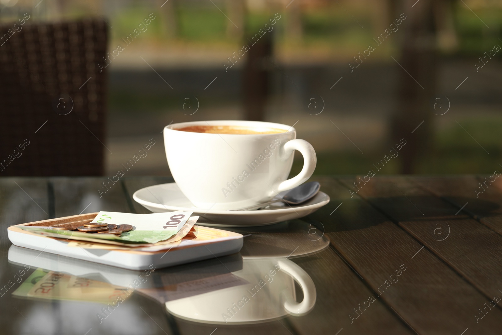 Photo of Tasty hot coffee and payment for order on table, space for text. Leave tip