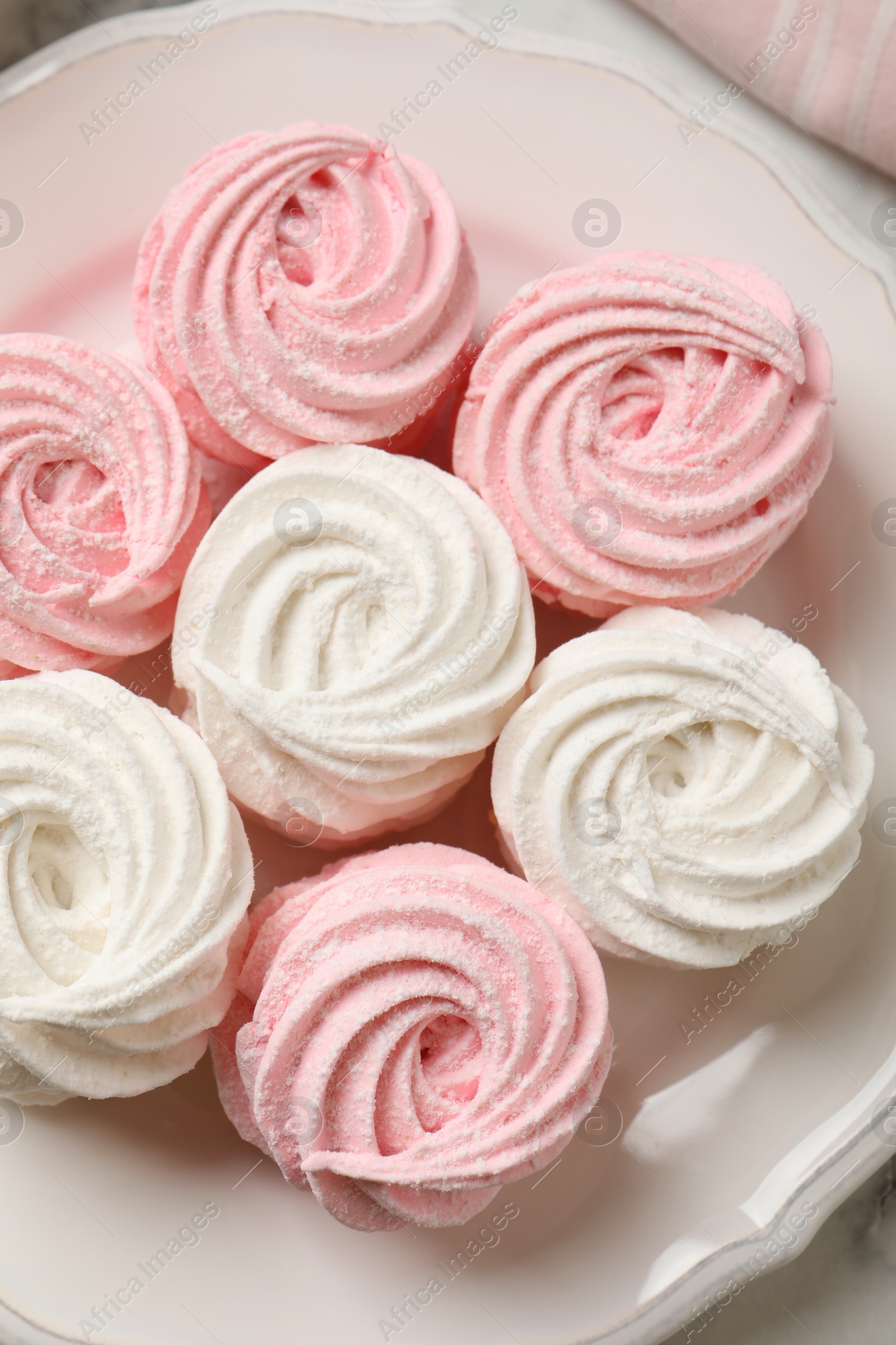 Photo of Delicious white and pink marshmallows on plate, top view