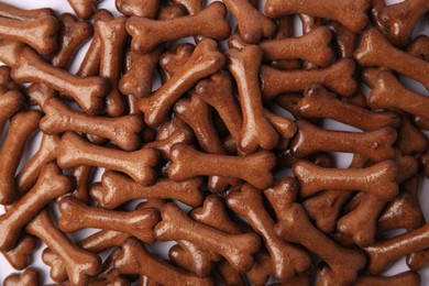 Photo of Many bone shaped dog cookies on white background, flat lay