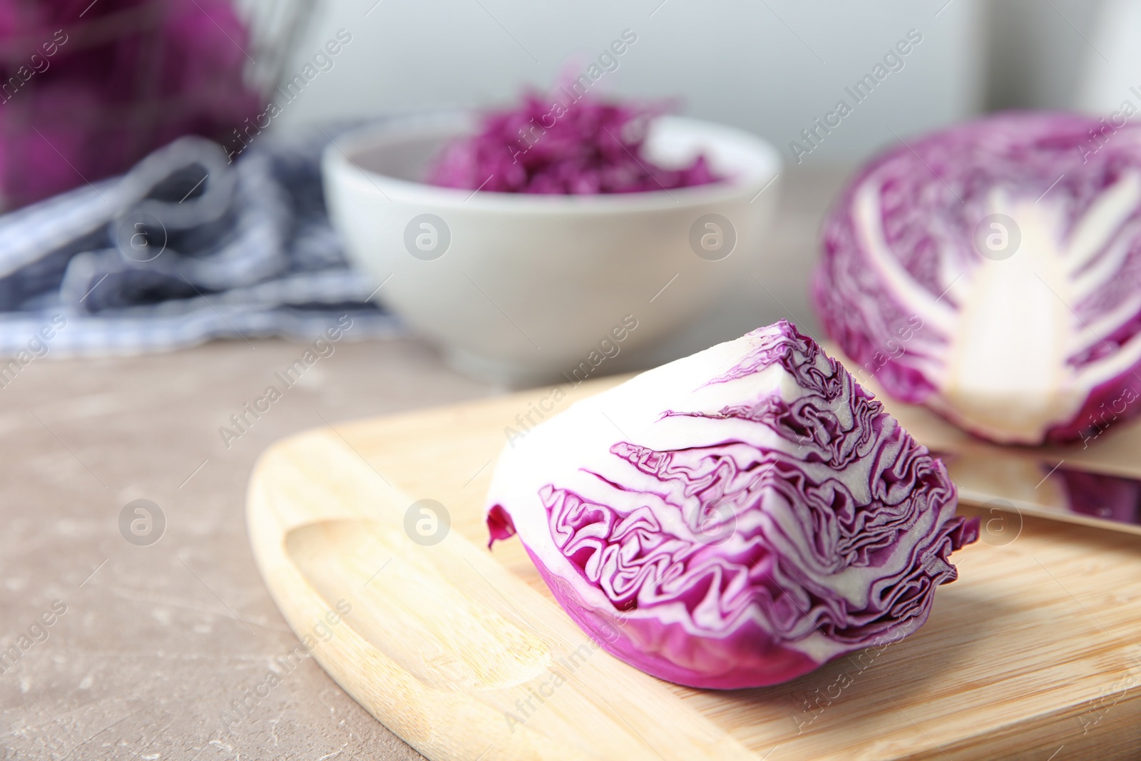 Photo of Fresh red cabbage and cutting board on kitchen table