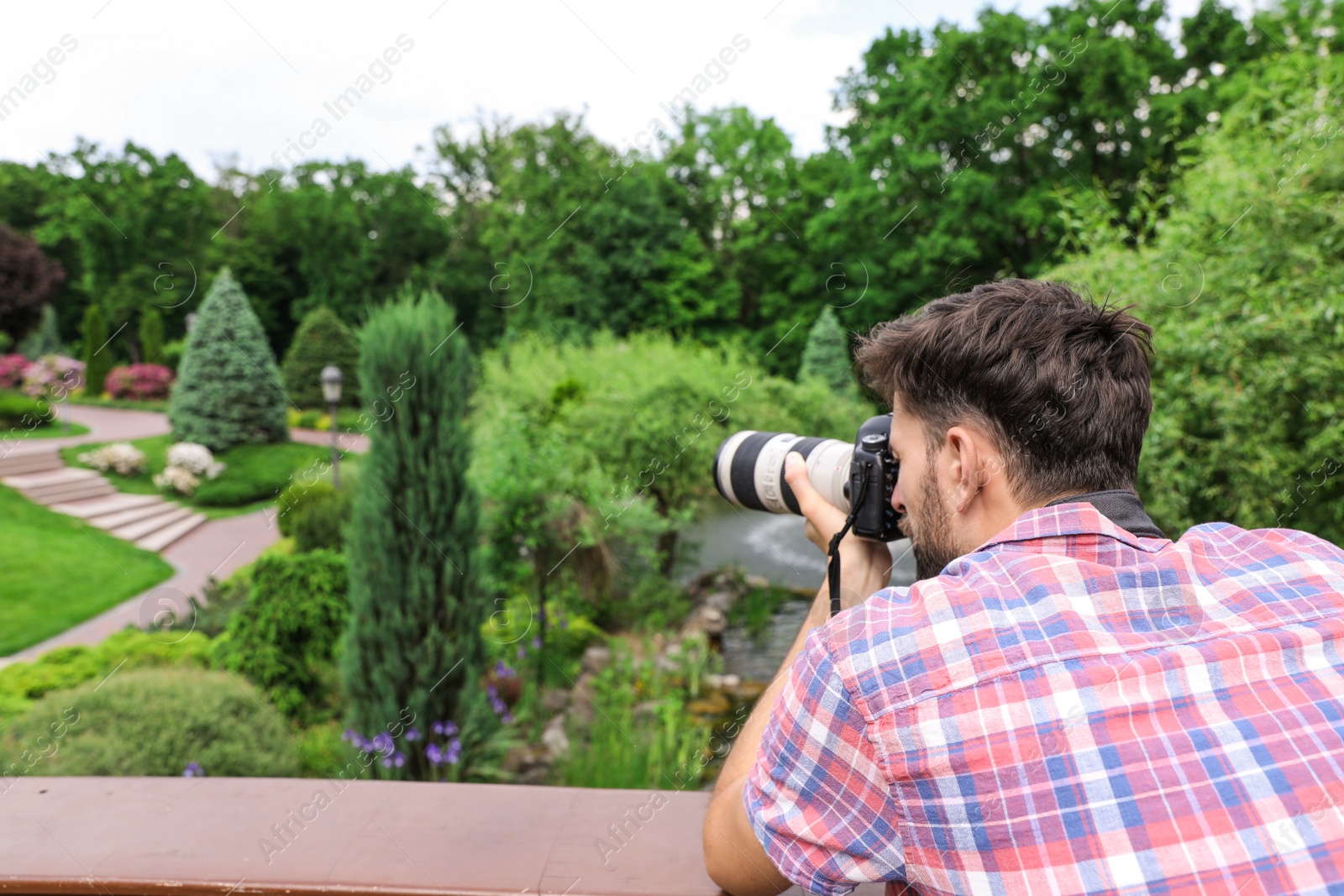 Photo of Photographer taking photo with professional camera in park