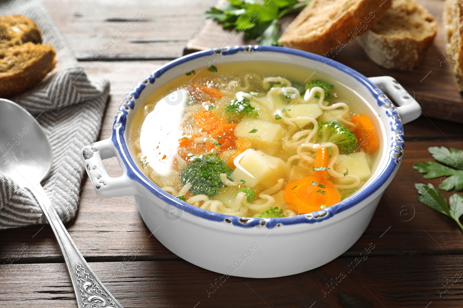 Photo of Dish of fresh homemade vegetable soup served on wooden table