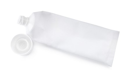 Photo of Blank tube of toothpaste on white background, top view
