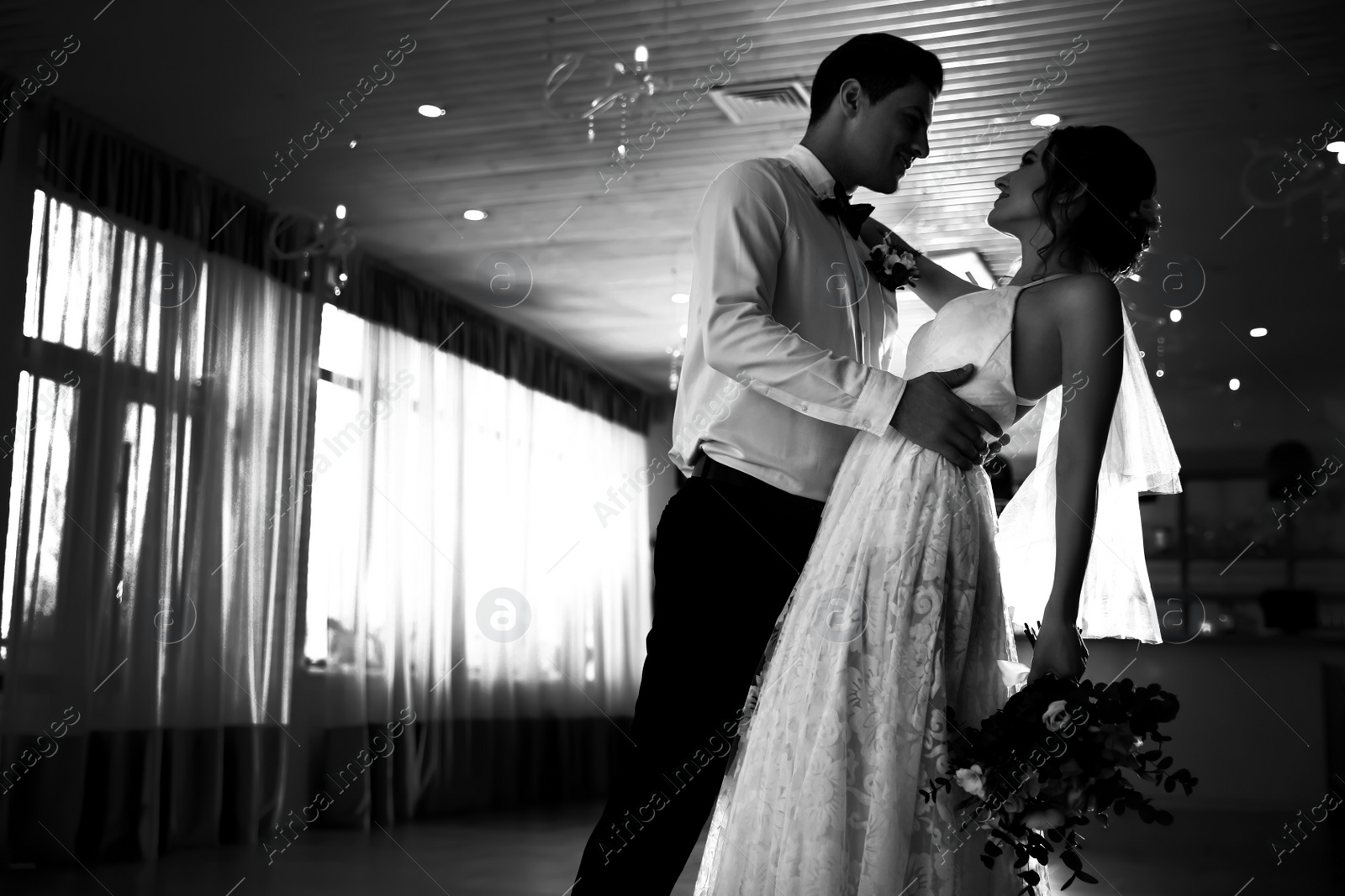 Image of Happy newlywed couple dancing together in festive hall