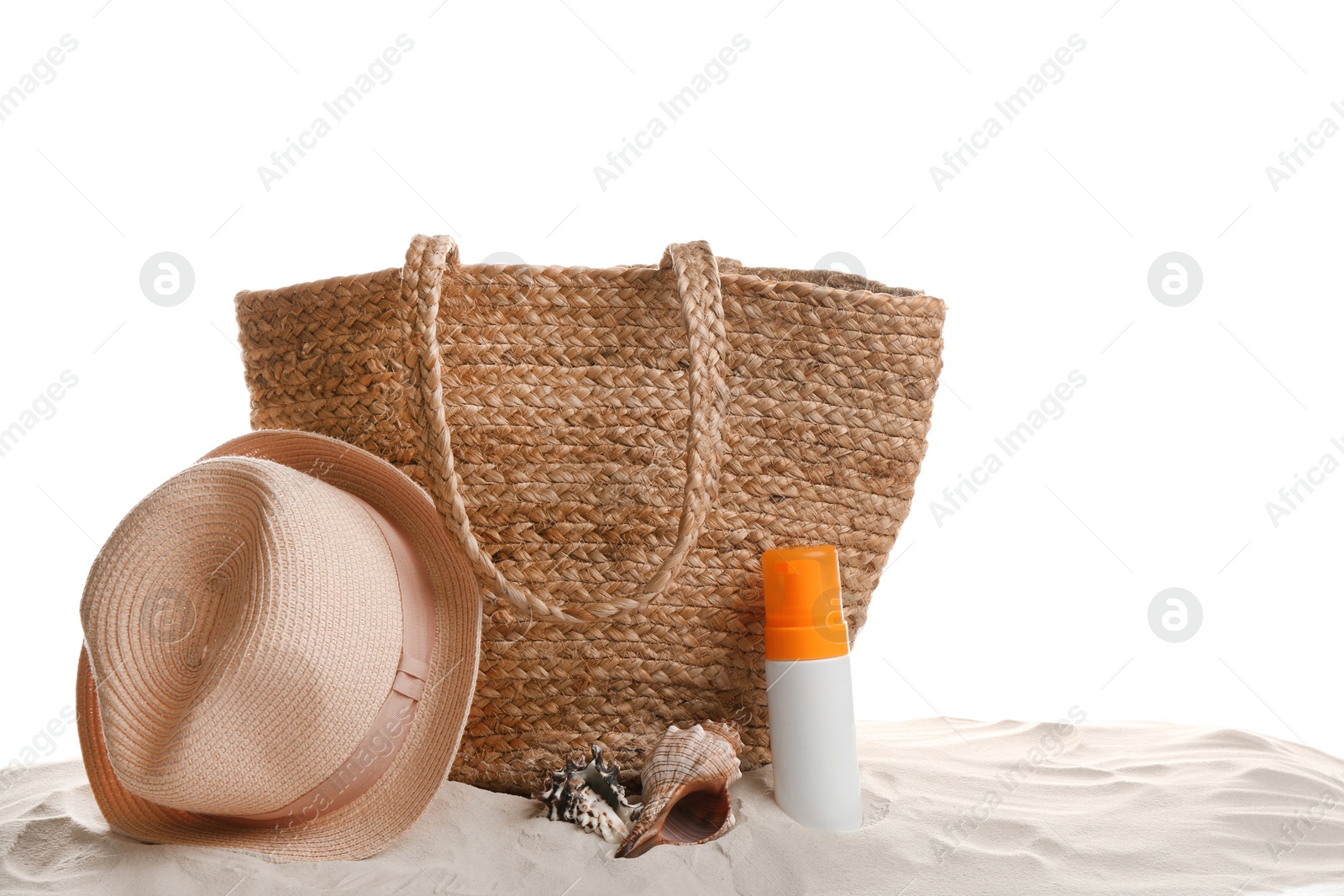 Photo of Stylish bag and beach accessories on sand against white background