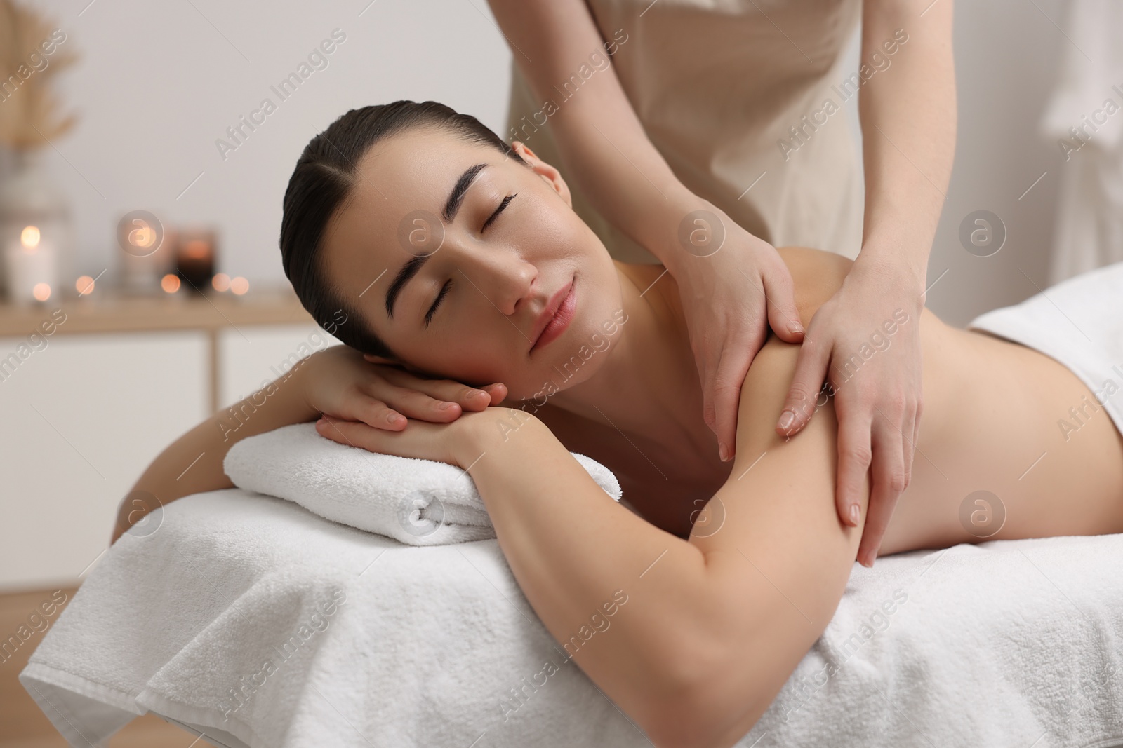 Photo of Woman receiving massage on couch in spa salon