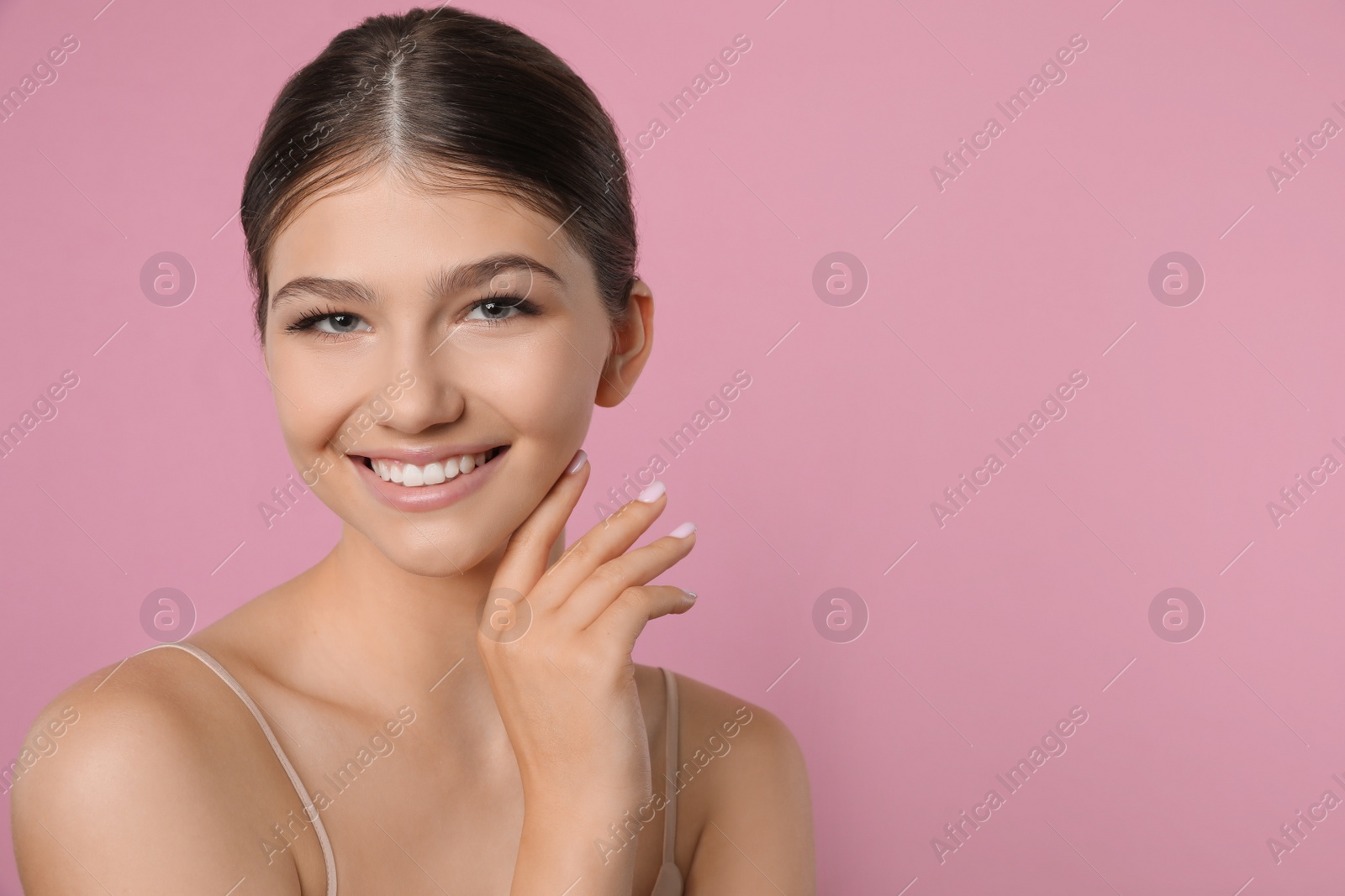 Photo of Portrait of pretty girl on pink background, space for text. Beautiful face with perfect smooth skin