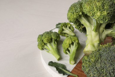 Photo of Fresh raw broccoli on white table, closeup. Space for text