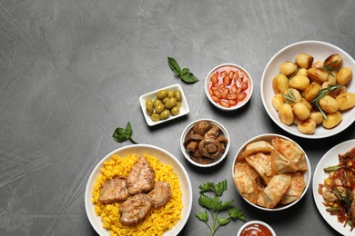 Photo of Buffet service. Flat lay composition with many  different dishes on grey table, space for text