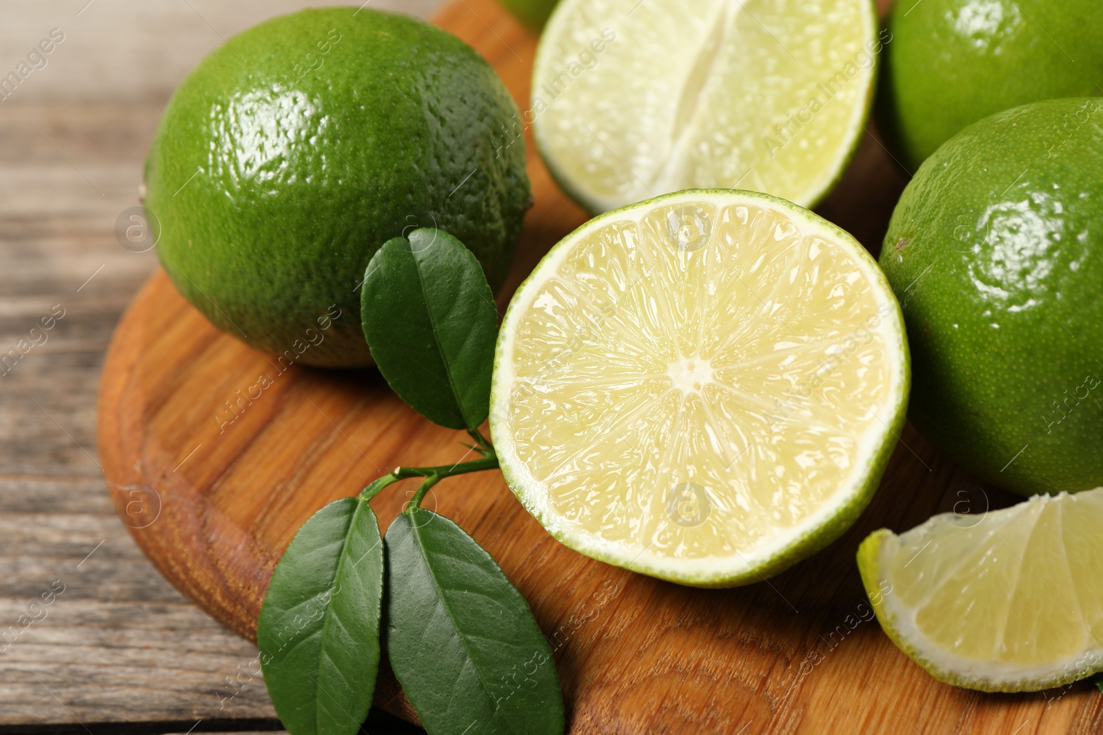 Photo of Fresh ripe limes on wooden table, closeup