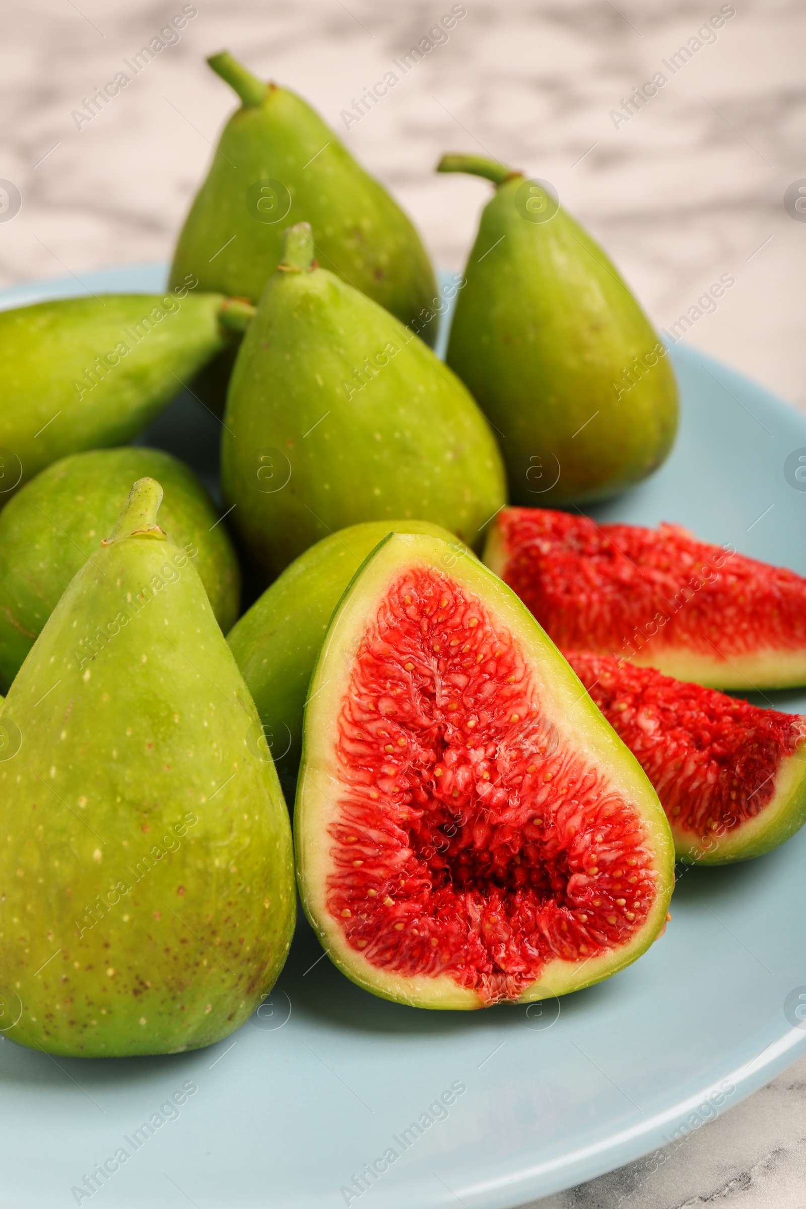 Photo of Cut and whole green figs on table, closeup