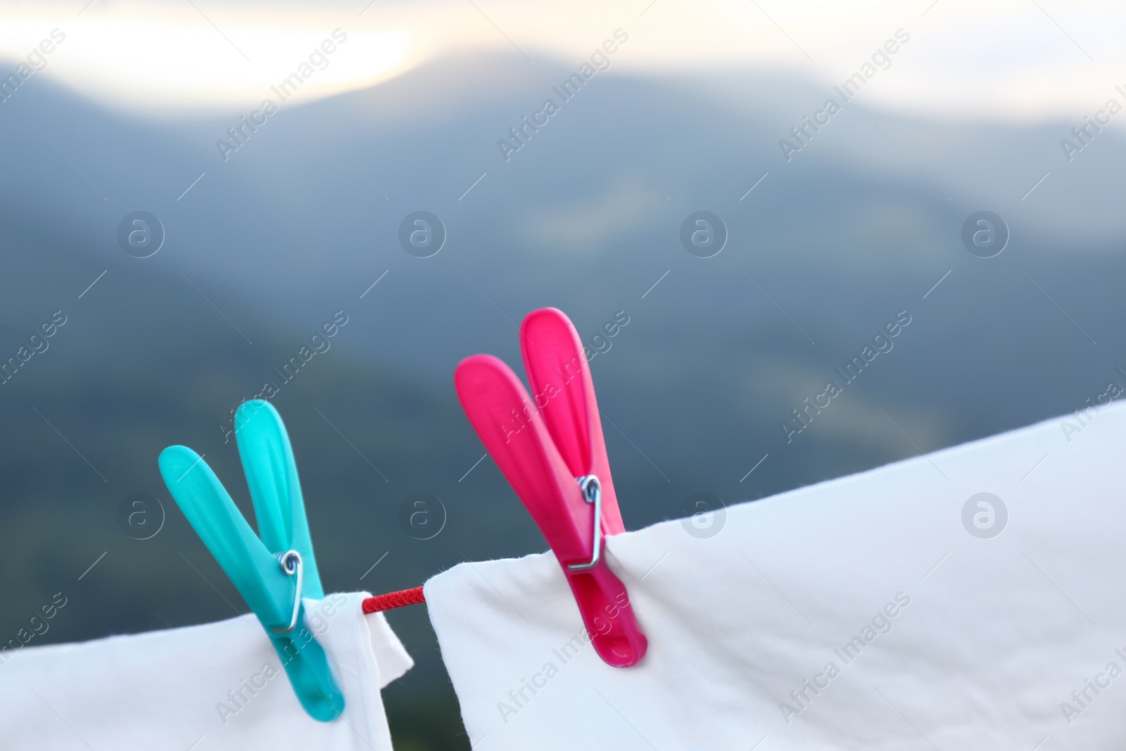 Photo of Bedclothes hanging on washing line in mountains, closeup