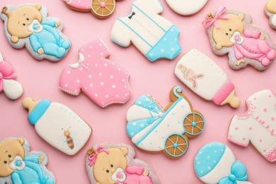 Cute tasty cookies of different shapes on pink background, flat lay. Baby shower party