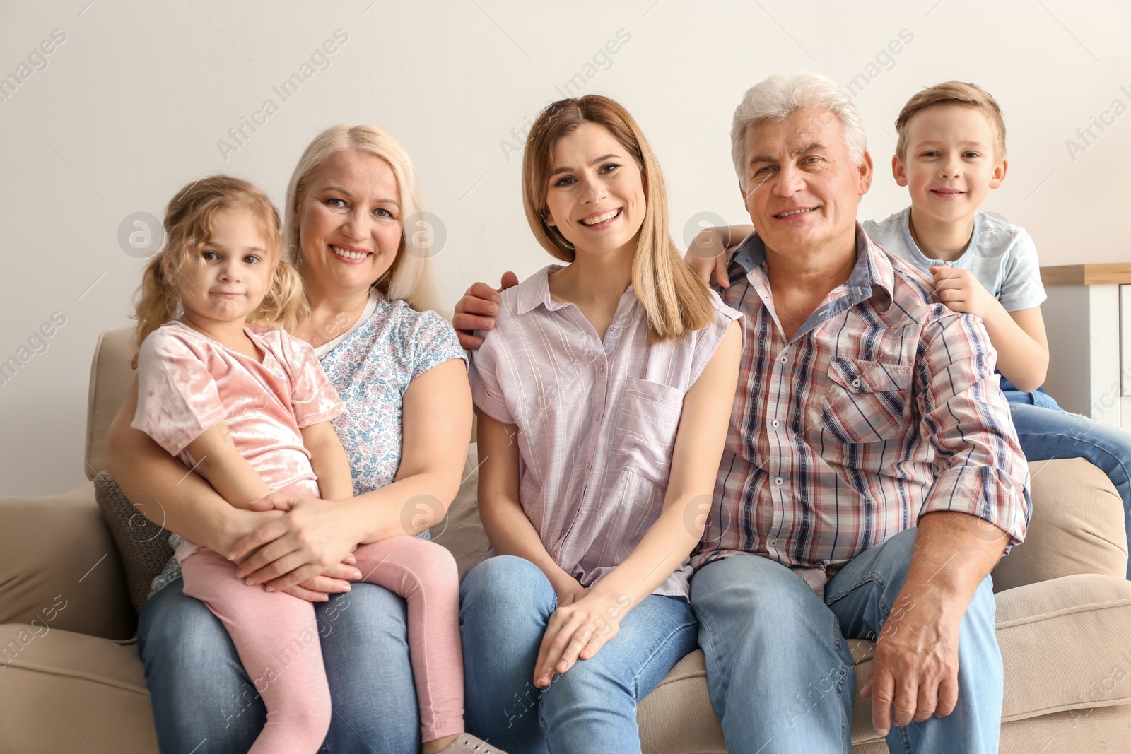 Photo of Happy family with cute kids on sofa at home