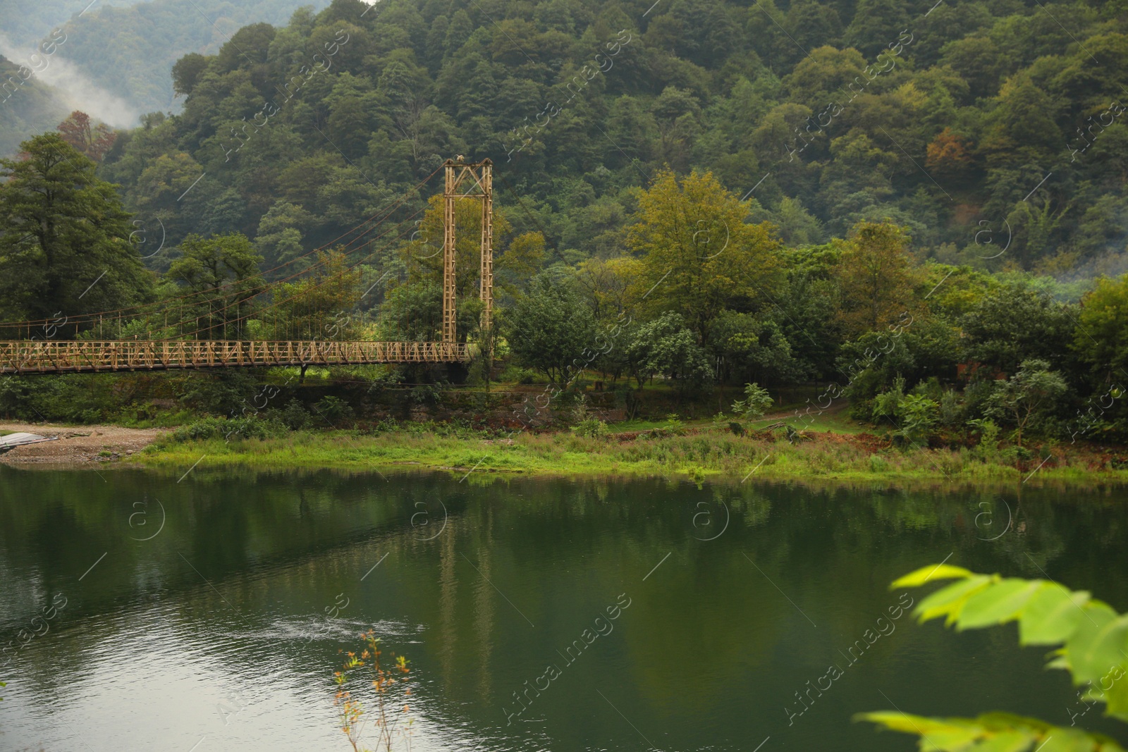 Photo of Rusty metal bridge over river in mountains