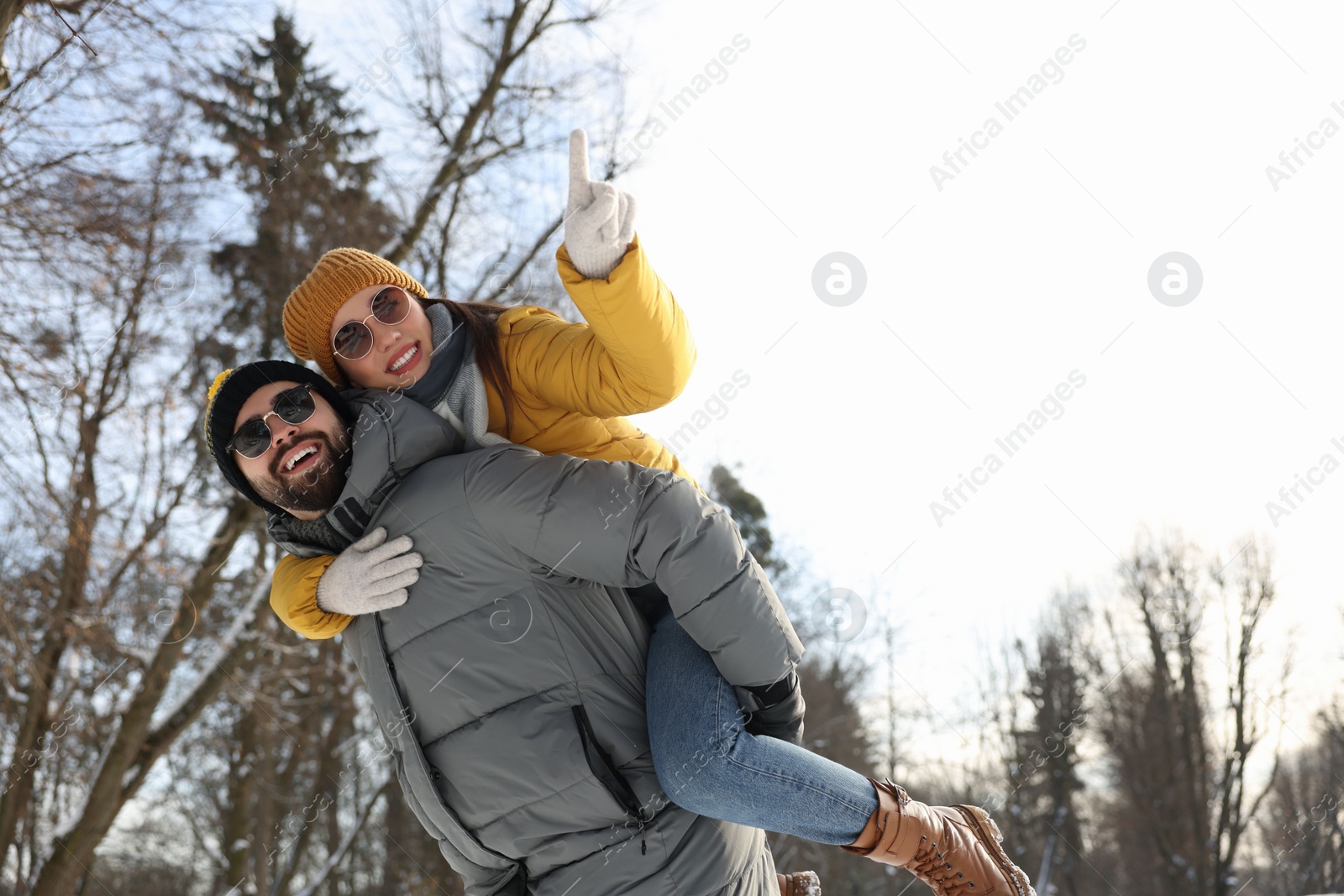 Photo of Happy young couple having fun outdoors on winter day, low angle view