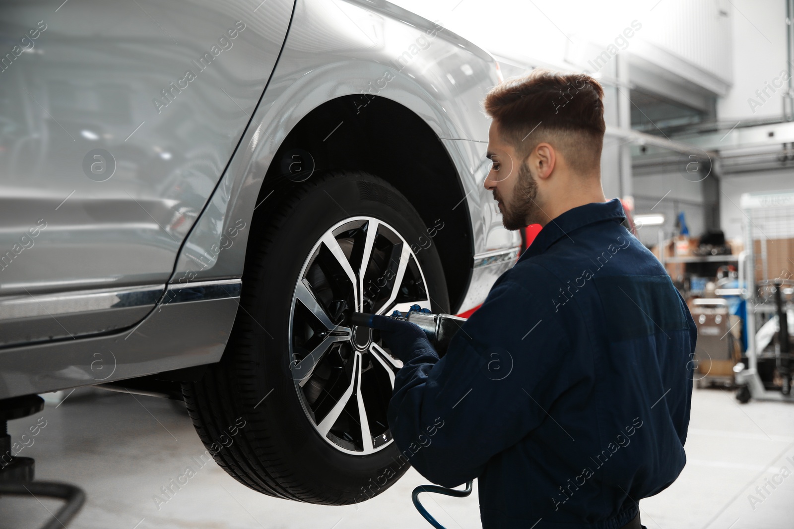 Photo of Technician working with car in automobile repair shop