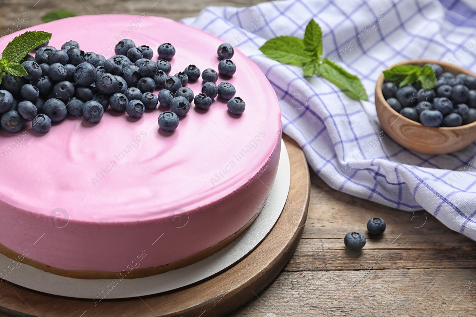 Photo of Board with tasty blueberry cake on wooden table. Space for text