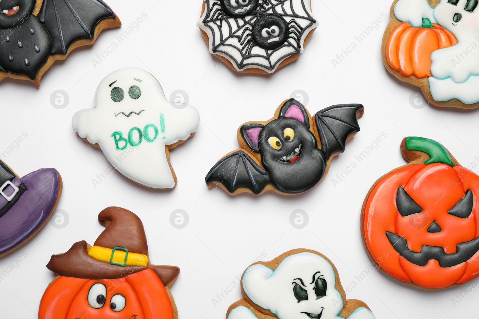 Photo of Tasty Halloween cookies on white table, flat lay