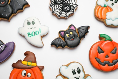 Tasty Halloween cookies on white table, flat lay