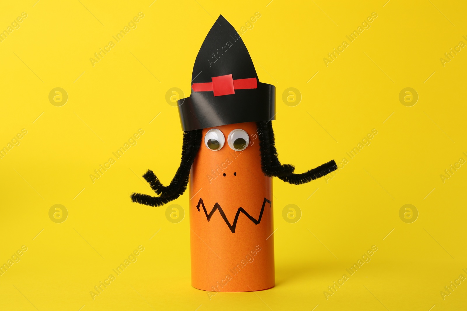 Photo of Funny orange monster on yellow background. Halloween decoration