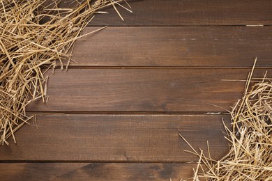 Photo of Dried straw on wooden table, top view. Space for text