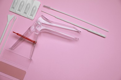 Sterile gynecological examination kit and medicaments on pink background, flat lay. Space for text