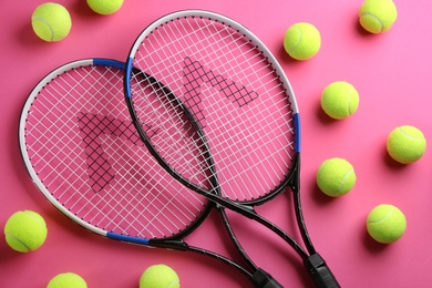 Photo of Tennis rackets and balls on pink background, flat lay. Sports equipment