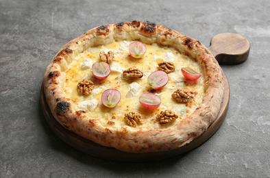 Delicious cheese pizza with walnuts and grapes on grey table