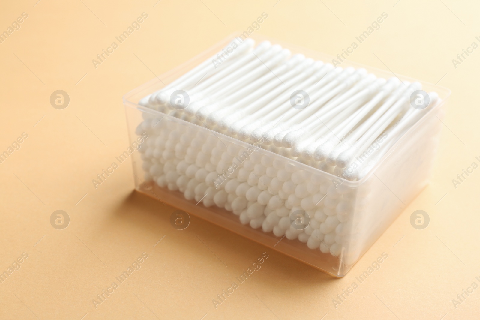 Photo of Plastic container with cotton swabs on color background