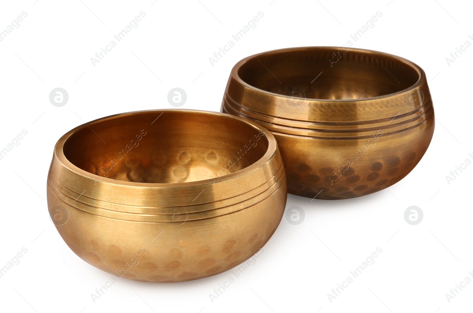 Photo of Golden singing bowls on white background. Sound healing