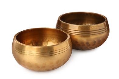 Photo of Golden singing bowls on white background. Sound healing