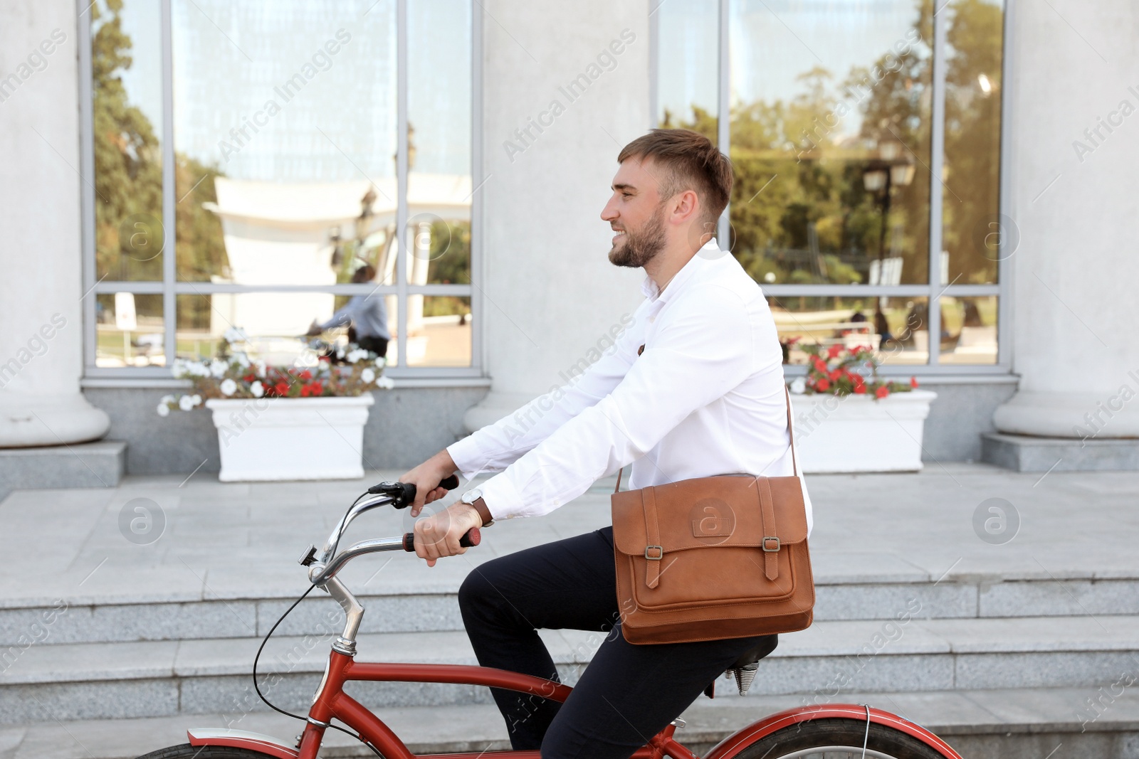 Photo of Attractive man riding bike on city street