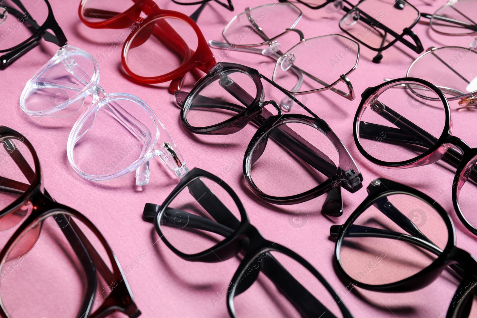Photo of Many different stylish glasses on pink background, closeup