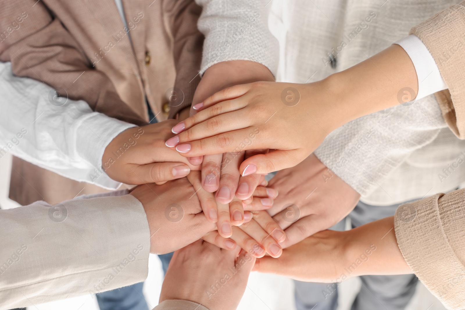 Photo of Group of people holding hands together indoors, closeup. Unity concept